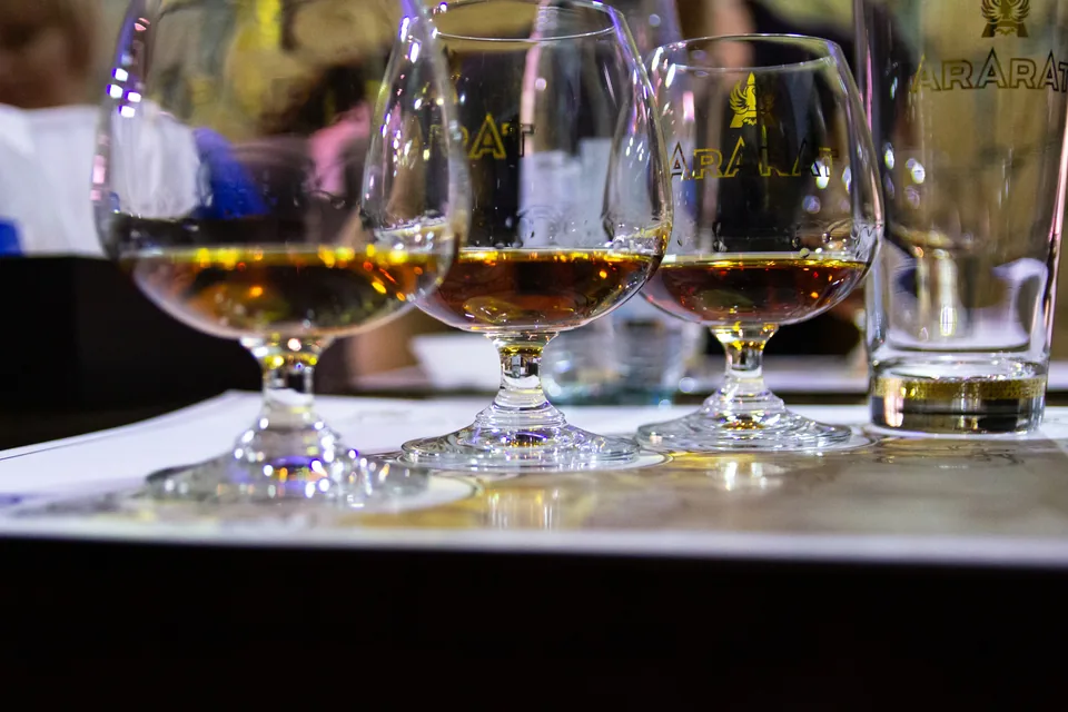 Oliva Serie V Melanio Review — row of cognac snifters holding amber spirit on a restaurant table