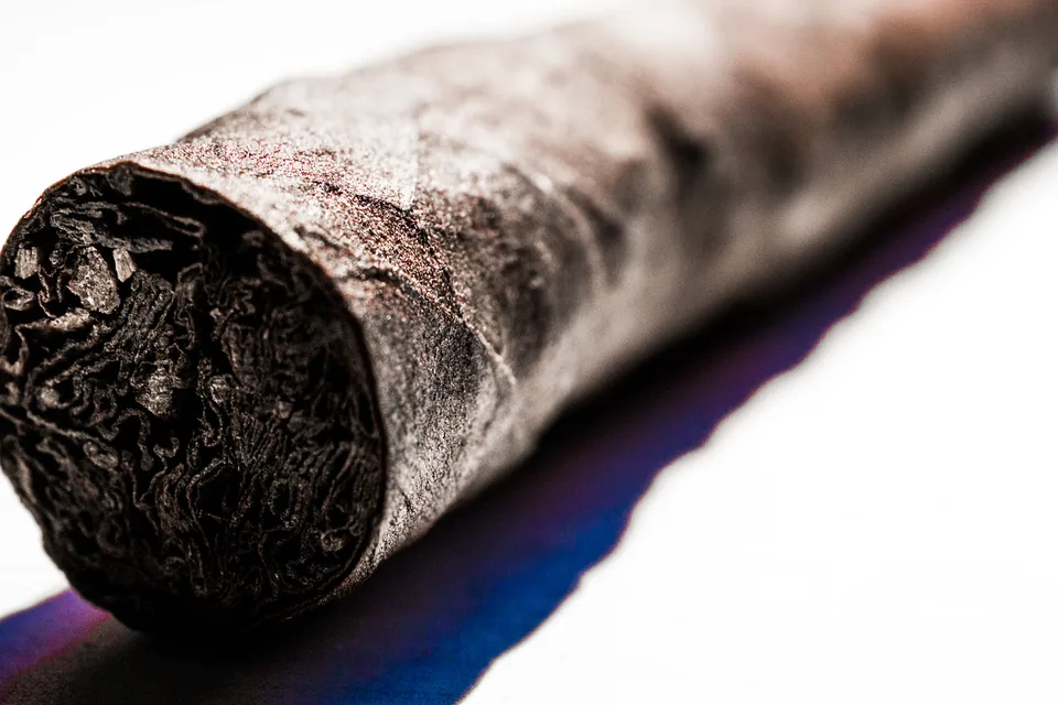 About Cigar Malaysia Guide: An Independent Cigar Publication — macro close-up of an unbranded cigar foot showing filler and dark wrapper texture